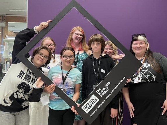 A group shot of teens holding a Blank Page photoframe