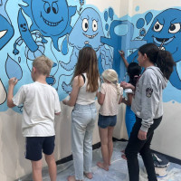 Teens painting a blue mural at Lowestoft Library