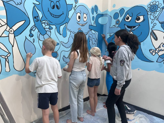Teens painting a blue mural at Lowestoft Library