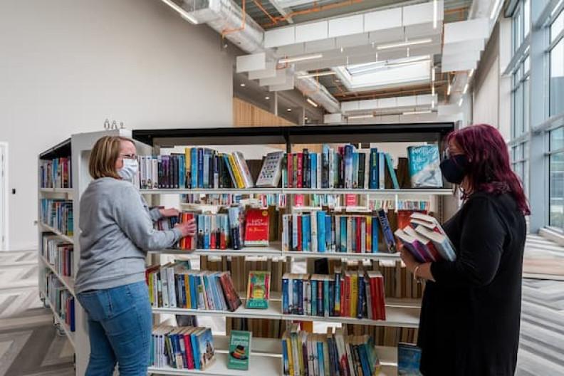 Library staff putting books on a shelf