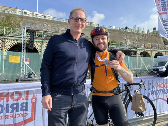 Bruce Leeke, CEO of Suffolk Libraries, greets Jacob Bathgate at the finish line after completing the London to Brighton cycle challenge.