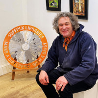 Spadge Hopkins with one of the metal daisies he sculptured.