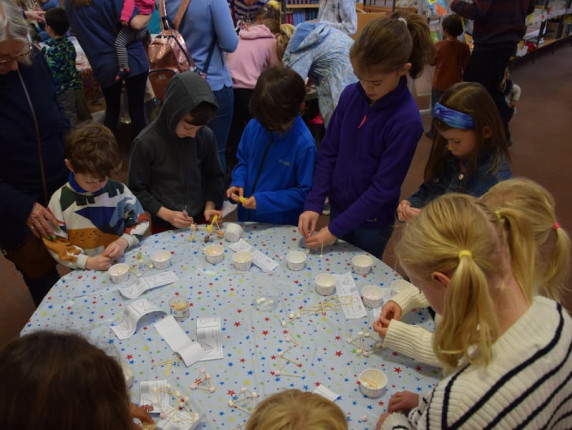 Children stood around a table engaging in STEM activities