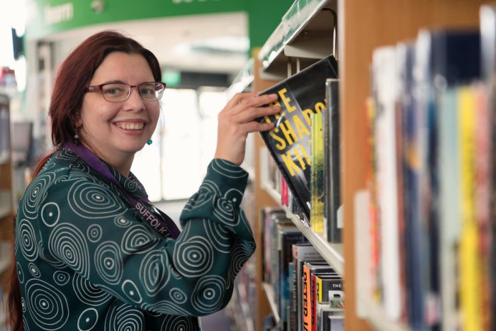 A member of staff shelving a book
