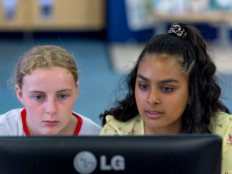 two young females looking at a computer screen