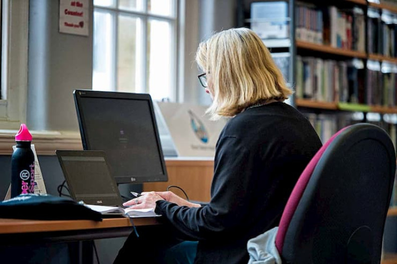 A woman sitting at a desk using a computer.