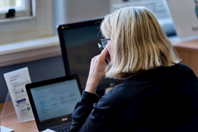 A woman sat at a desk looking at a computer.
